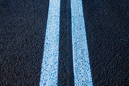 Road markings on asphalt on the street. White dividing line and special road marking symbols on black asphaltの写真素材