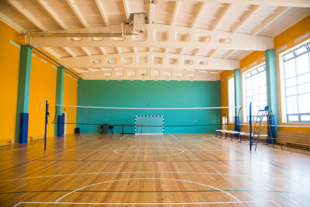 Modern new school building. Empty school gymnasium with yellow floor and climbing near wallsの写真素材