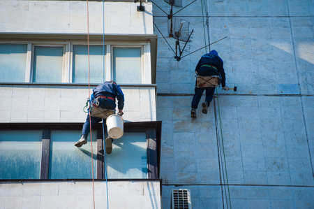 Climbers carry out construction and installation work on the facade of the buildingの写真素材