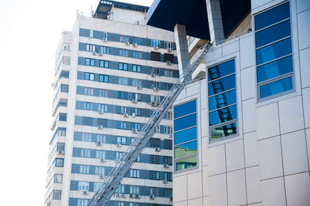 A sliding fire escape is used by emergency services to allow access to the buildingの写真素材