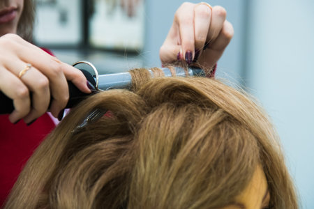Beauty shop. Barber does hair styling. Barber's hands close upの写真素材