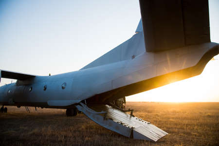 The plane is standing in a field with an open cargo bayの写真素材
