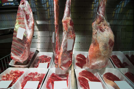 Meat in the packaging and price tags is on the shelves of the store for further saleの写真素材