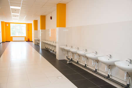 Row of modern white ceramic wash basin in public toilet or restaurant or hotel or shopping mallの写真素材