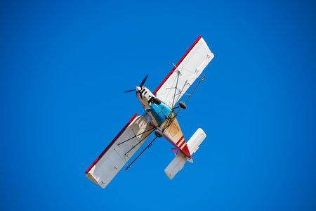 Small aircraft against the blue sky. Flight of an agricultural aviation aircraft