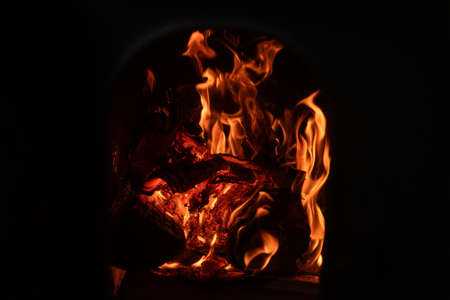 A fire burns in a fireplace. Fire to keep warm. A beautiful fire burning in a cozy fireplace for Christmasの写真素材