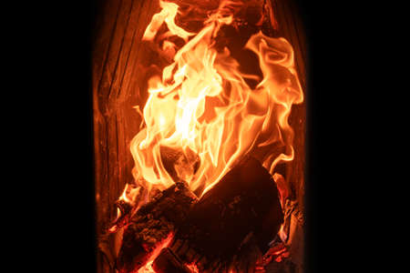 A fire burns in a fireplace. Fire to keep warm. A beautiful fire burning in a cozy fireplace for Christmasの写真素材