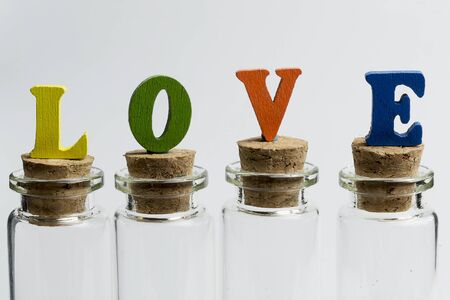 Glass flasks on a white background with the word love.の写真素材
