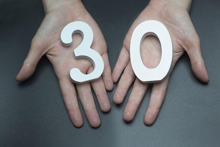 female hand with a figure thirty.の写真素材