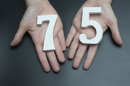 Female hand with numbers seventy-five.の写真素材