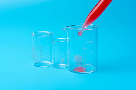 Pipette adding blood to one of several test tubes on a blue background.の写真素材