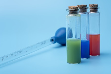Tubes with different liquid inside on blue background.の写真素材