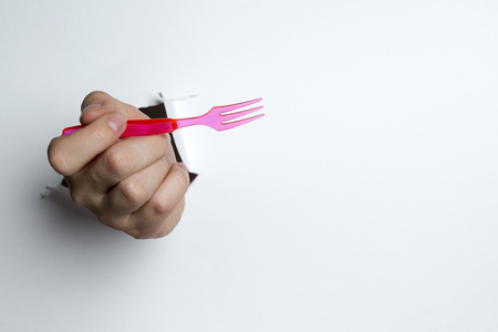 Disposable fork in hands isolated on white backgroundの写真素材