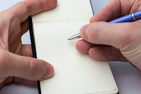 Hand writing on empty notepad isolated on white