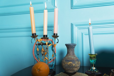 A candlestick with a jug is on a table with orange.の写真素材