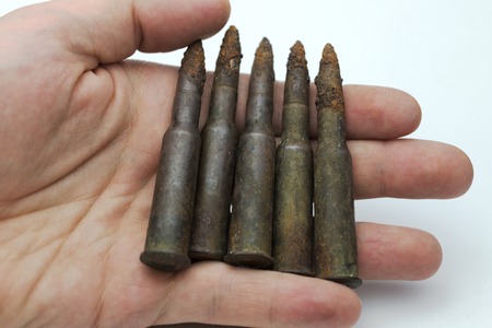 Hand holds the old bullet cartridges on a white background.の写真素材
