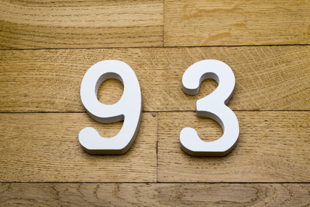 Figures ninety-three on a wooden, parquet floor as a background.の写真素材
