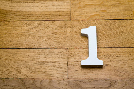 Number one on a wooden, parquet floor as a background.