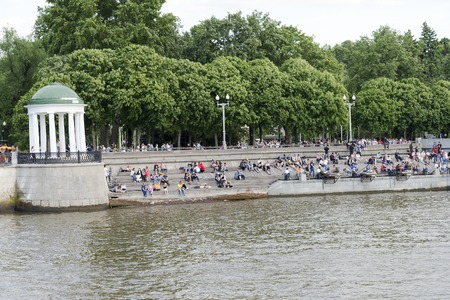 People on the waterfront sitting on the stairs on a Sunny day, Moscow, Russia.のeditorial素材