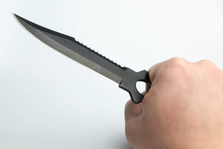 Hand on a white background holding a knife for cutting.