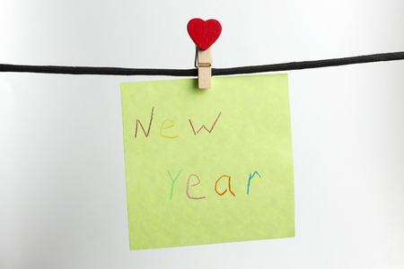 Paper weighs on the black rope with the words happy new year on white background.の写真素材