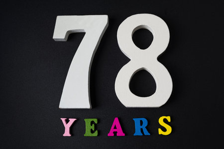 Letters and numbers seventy-eight years old on a black isolated background.
