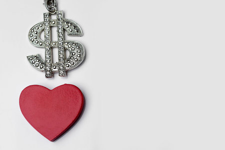 The dollar sign and red heart on a white background.の写真素材
