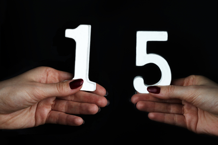 On black background female hands with number fifteen.の写真素材