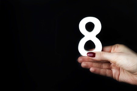 On a black background, female hand with a figure eight.の写真素材