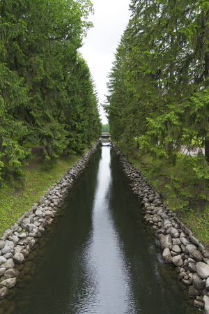 A small water channel with coniferous trees and a bridge in the Catherine Park, Pushkin village.のeditorial素材