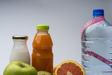 Female fitness still life. Healthy food, fruit, juice and water on grey background. Fitness, sports and healthy lifestyle concept.の写真素材