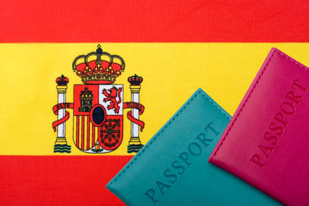 On the background of the Flag of Spain lie the passport. Travel and tourism concept.の写真素材