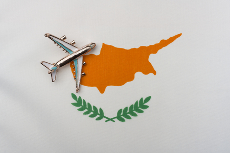 Airplane over Cyprus flag travel and tourism concept. Toy plane on the flag in the background.の写真素材