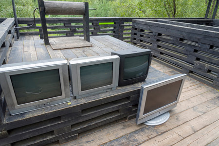 Lots of old TVs on a wooden table. Old TVs are like garbage.の写真素材