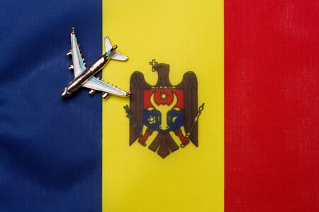 The plane over the flag of Moldova is the concept of travel and tourism. Toy plane on a flag in the background.の写真素材