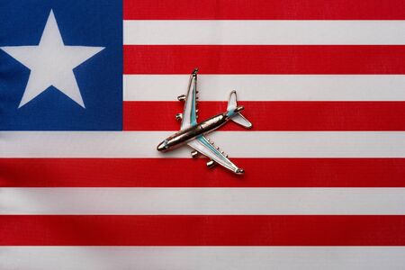 Airplane over Liberia flag island travel concept. Toy plane on a flag in the background.の写真素材