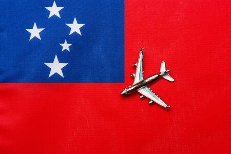 Plane over the flag of Samoa the concept of travel and tourism. Toy plane on a flag in the background.の写真素材