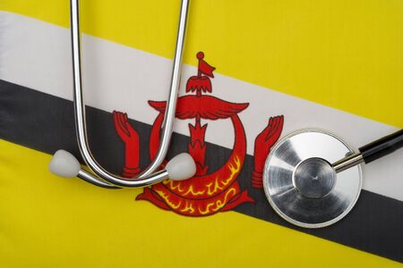 Flag of Brunei Darussalam and stethoscope. The concept of medicine. Stethoscope on the flag in the background.の写真素材