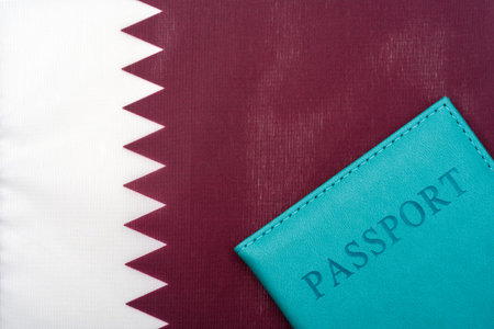 On the background of the flag of Qatar is a passport. The concept of travel and tourism.