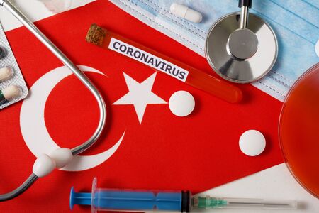 Coronavirus, nCoV concept. Top view protective breathing mask, stethoscope, syringe, pills on the flag of Turkey. A new outbreak of the Chinese coronavirusの写真素材