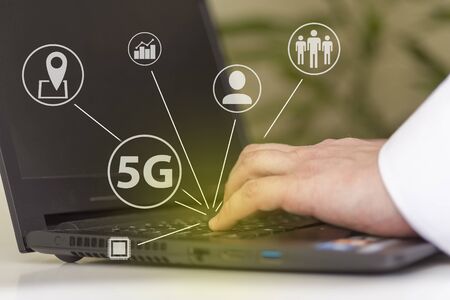 5G telecommunications business technology is a web-based network concept. Internet technology LTE. Hands on the laptop keyboard.の写真素材