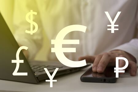Foreign currency exchange concept, forex trading. Dollar, euro, pound and yen signs with businessman working on computer on background.の写真素材