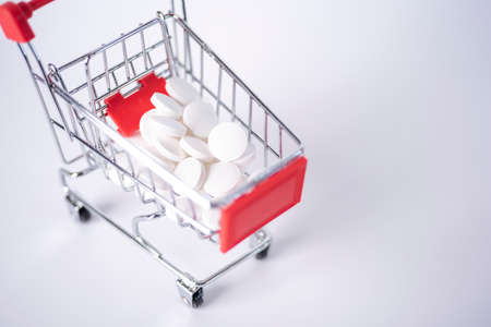 Shopping Cart Filled with Capsules Isolated On White Background. The concept of buying medicines in large quantities.の写真素材