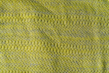 Macro view of yellow knitting. Horizontal orientation, Texture of yellow wool fabric.