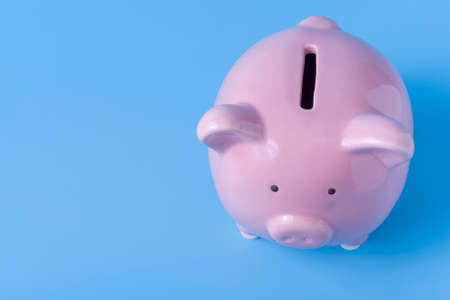 Cute pink piggy Bank On a blue background for savings and purchases. The concept of money accumulation and prospects.の写真素材