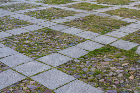 Granite cobblestoned pavement background. Full frame of regular square cobbles in rows. Natural stone textured backgroundの写真素材
