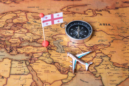 Flag of Georgia, compass and plane on the world map. The concept of travel and tourism.の写真素材