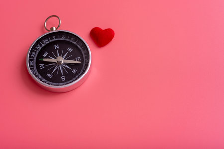 Compass and heart on a pink background, the direction of love. the concept of love and happiness.の写真素材