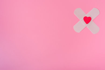 medical patch and heart on a pink background. The concept of healing of wounds and cuts.の写真素材