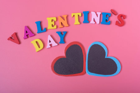 The word Valentine's day and two hearts on a pink background. The concept of love and happiness on...